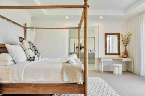 sypialnia z łóżkiem z baldachimem i lustrem w obiekcie Luxury Hunter Valley Estate w mieście Lochinvar
