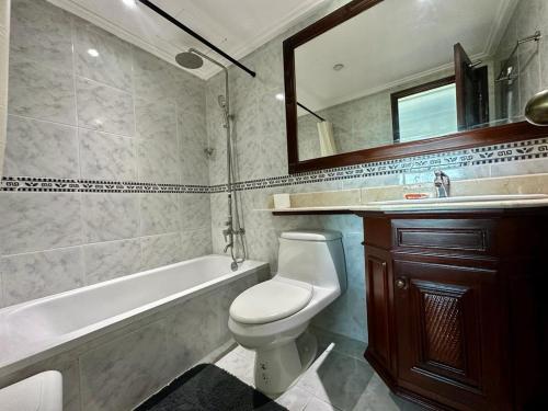 een badkamer met een bad, een toilet en een wastafel bij Gateway For You And Your Loves Ones I Sleeps 6 in Santo Domingo