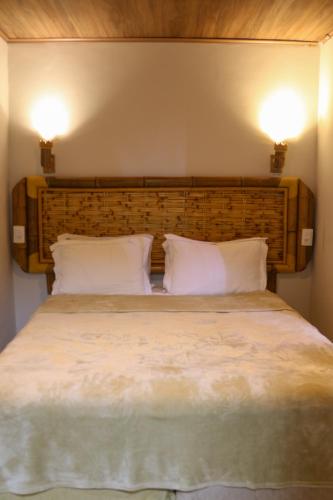 a bedroom with a large bed with two pillows at Casa do Imperador in Fernando de Noronha