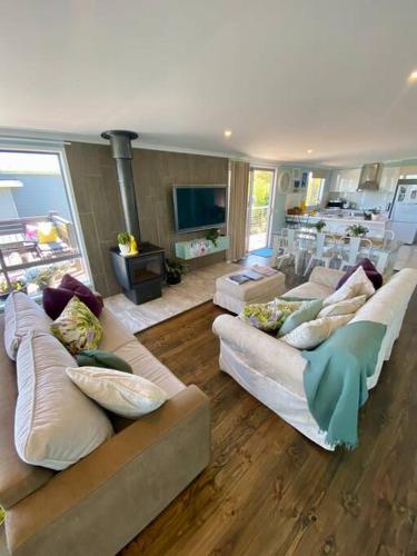 a living room with two couches and a fireplace at Salty Paws Dog Friendly Luxe Cottage in San Remo