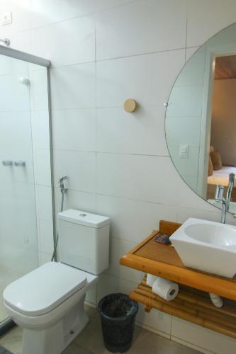 a bathroom with a toilet and a sink and a mirror at Casa do Imperador in Fernando de Noronha