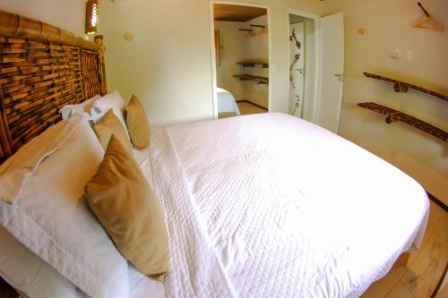 a bedroom with a large white bed with pillows at Casa do Imperador in Fernando de Noronha