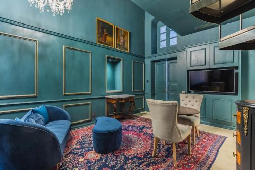 a living room with blue walls and a tv and chairs at House of W in Valletta