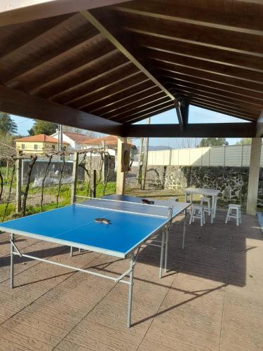 a blue ping pong table under a roof at Quinta de Esteves - Lake House Suites in Ponte de Lima