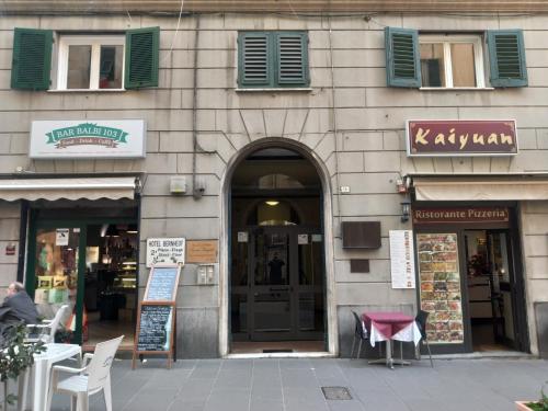 un edificio con ventanas con persianas verdes y una puerta en B&B Italian Guest Genova, en Génova