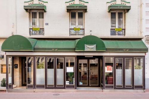 einen Laden mit grüner Markise auf einem Gebäude in der Unterkunft Crystal Hotel in Levallois-Perret