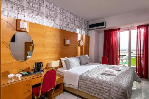 una camera con letto, scrivania e specchio di City Life Hotel a Heraklion