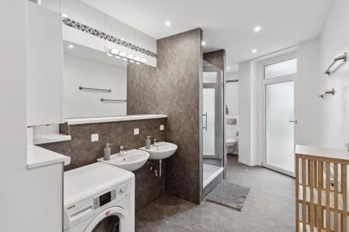 biała łazienka z 2 umywalkami i lustrem w obiekcie Apartment für 10 Gäste, 2 Bäder, 2 Loggia's, Leipzig Zentrum Ost w Lipsku
