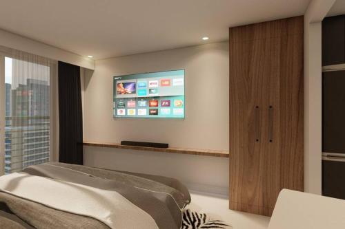 een slaapkamer met een flatscreen-tv aan de muur bij Sevilla's Place in Tagaytay