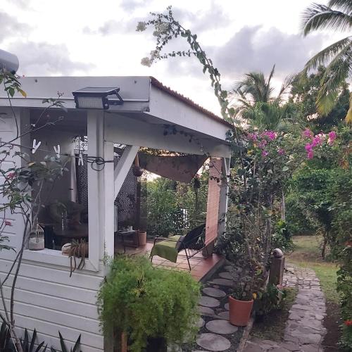 a white pergola on a house with plants at Le Biabiany in Bouillante