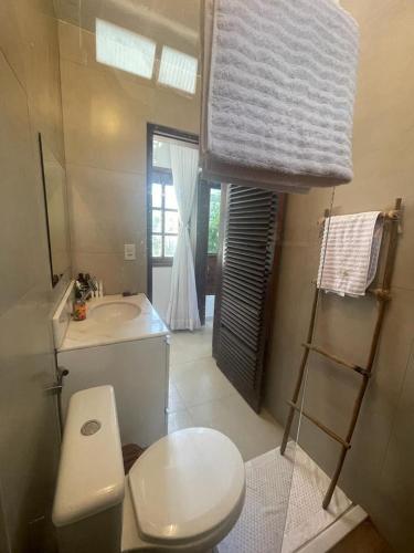 a small bathroom with a toilet and a sink at Casa das Lunas in Praia do Forte