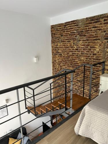a loft bedroom with a brick wall and a bed at Loft .Once de Abril in Bahía Blanca