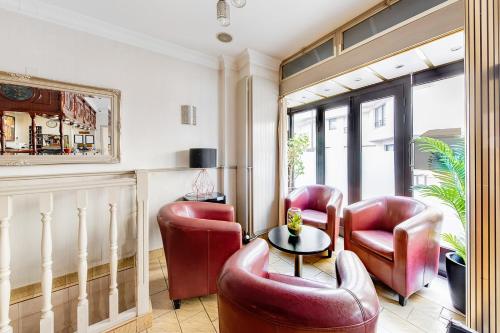ein Wohnzimmer mit roten Stühlen und einem Tisch in der Unterkunft Crystal Hotel in Levallois-Perret