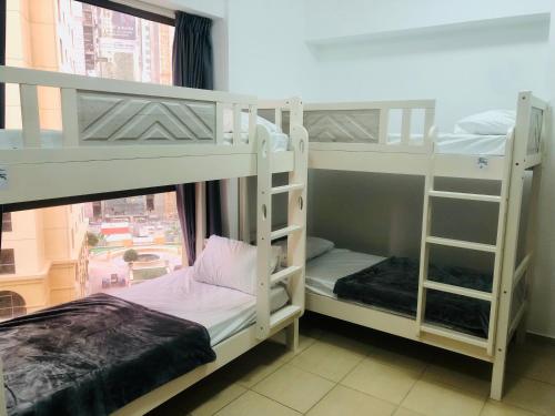 two bunk beds in a room with a window at The beach hostel Dubai in Dubai