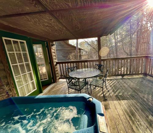 a jacuzzi tub on a deck with a table at C13 - Forest View two bedroom, two bath Harbor North luxury loft cottage with private hot tub o Lake on Ouachita in Mount Ida