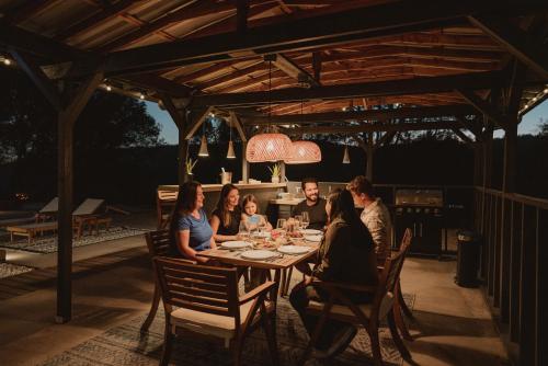 a group of people sitting around a table on a patio at Boho chic oasis by Casa Oso with pool, spa and views in Ahwahnee