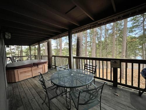 een terras met een tafel en stoelen bij Mountain Harbor Lodge cottage on Lake Ouachita in Mount Ida