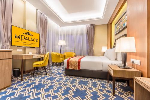 a hotel room with a bed and a desk at MPalace Hotel KL in Kuala Lumpur