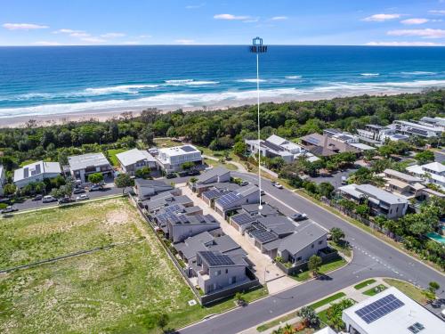 une vue aérienne d'un complexe hôtelier avec l'océan dans l'établissement Sunfish Special - Beachside Townhouse by uHoliday, à Kingscliff