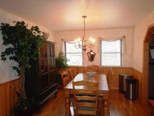 a dining room with a table and a chandelier at Luxury, loft, log-sided two bedroom Harbor North cottage cottage in Mount Ida