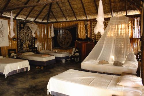 a bedroom with two beds and a net at Escondite Pacifico in Popoyo