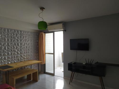 ein Wohnzimmer mit einem Tisch und einem TV in der Unterkunft Ap próx shopping aeroporto in Recife