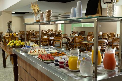 uma linha de buffet com alimentos e bebidas ao pequeno-almoço num restaurante em GH Hotel Express em Juiz de Fora
