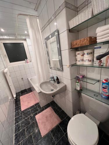 La salle de bains est pourvue de toilettes blanches et d'un lavabo. dans l'établissement OTTO Apartment Bremen, à Brême