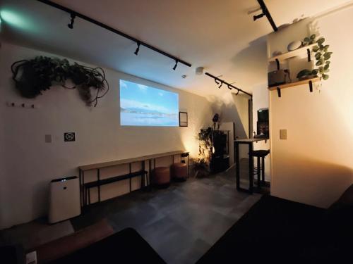 a room with a projection screen on the wall at Eden House in Tokyo