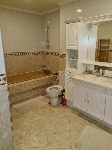 une salle de bain avec toilettes, baignoire et lavabo dans l'établissement Loft aux portes de Paris : 200m2, à Bagnolet