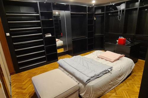 Cette chambre comprend un lit et un banc. dans l'établissement Loft aux portes de Paris : 200m2, à Bagnolet