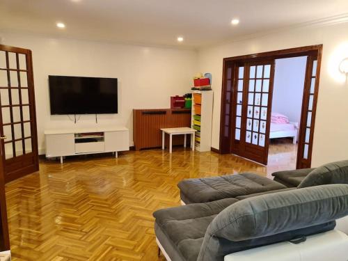 ein Wohnzimmer mit einem Sofa und einem Flachbild-TV in der Unterkunft Loft aux portes de Paris : 200m2 in Bagnolet