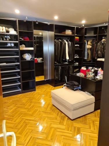 - un dressing avec un pouf blanc au milieu d'une pièce dans l'établissement Loft aux portes de Paris : 200m2, à Bagnolet
