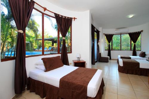 sypialnia z 2 łóżkami i dużym oknem w obiekcie Natura Gardens Galápagos w mieście Bellavista