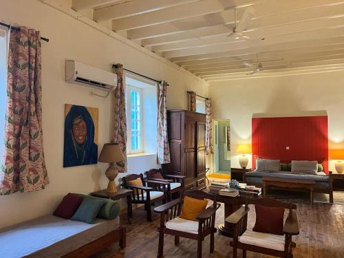 un soggiorno con divano, tavoli e sedie di Principauté a Gorée