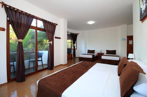 a bedroom with a large bed and a large window at Natura Gardens Galápagos in Bellavista