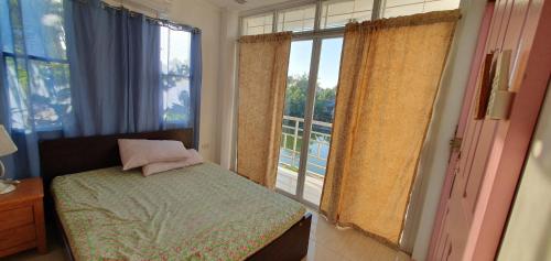 um quarto com uma cama e uma grande janela em House for Rent Iloilo Arevalo em Iloilo