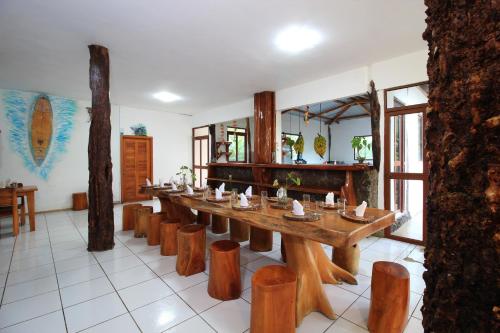 a long wooden table and chairs in a room at Natura Gardens Galápagos in Bellavista