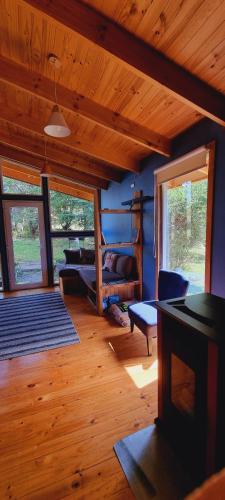 - un salon avec un lit et un plafond en bois dans l'établissement Martín Pescador Cabañas, à Coyhaique