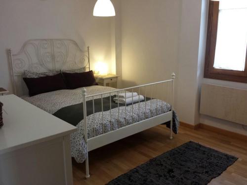 a bedroom with a white bed and a window at Apartamento Bielsa-Monte Pérdido in Bielsa