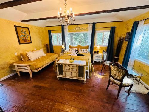 ein Schlafzimmer mit gelben Wänden, einem Bett und einem Tisch in der Unterkunft Flume's End in Nevada City