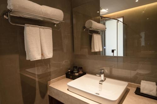 uma casa de banho com um lavatório e um espelho em S&N Xuanting Hotel Pengze em Pengze