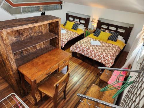 a view of a room with two beds and a desk at Edificio El Barrio Vertical in San José