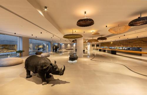 Habitación grande con una estatua de un rinoceronte en el suelo en Travelodge Nimman en Chiang Mai