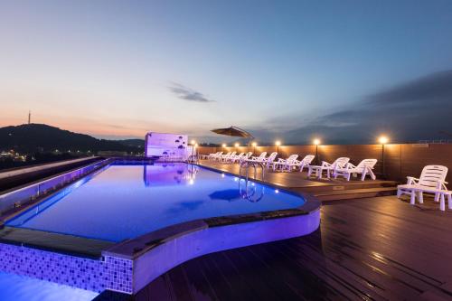 a swimming pool on the roof of a building at night at Casaloma Hotel in Seogwipo