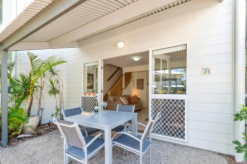 een patio met een tafel en stoelen op een huis bij Coco Bay Resort in Noosaville