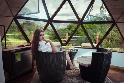 a young girl sitting in a room with a window at Hotel Campestre La Periquera in Villa de Leyva