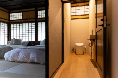 a bedroom with a bed and a door with a mirror at Hotel mio in Shimabara