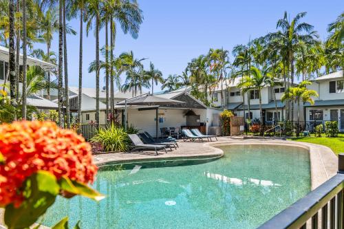 a swimming pool in a resort with palm trees at Coco Bay Resort in Noosaville
