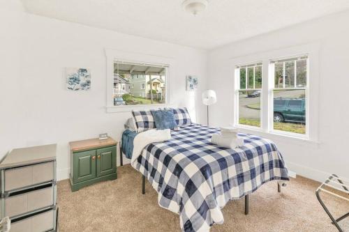 a bedroom with a bed and a table and windows at Beautiful home, Central location, Close to Beach in Seattle